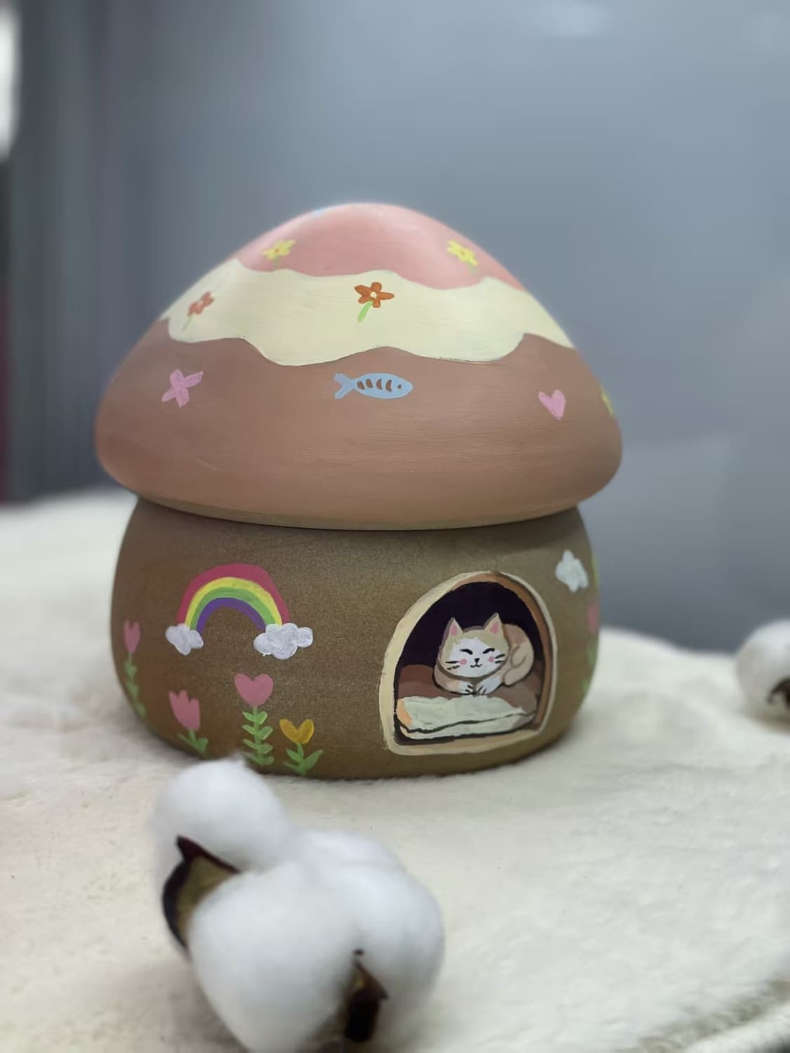 A Mushroom Sleep House painted by its owner: a rainbow, hearts and a cat asleep in the doorway